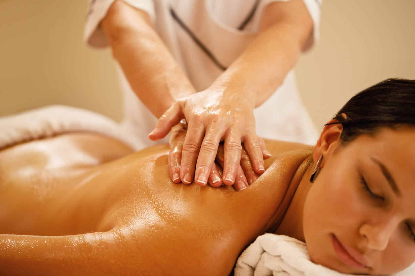 Massoterapeuta aplicando massagem corporal nas costas de uma cliente em Curitiba